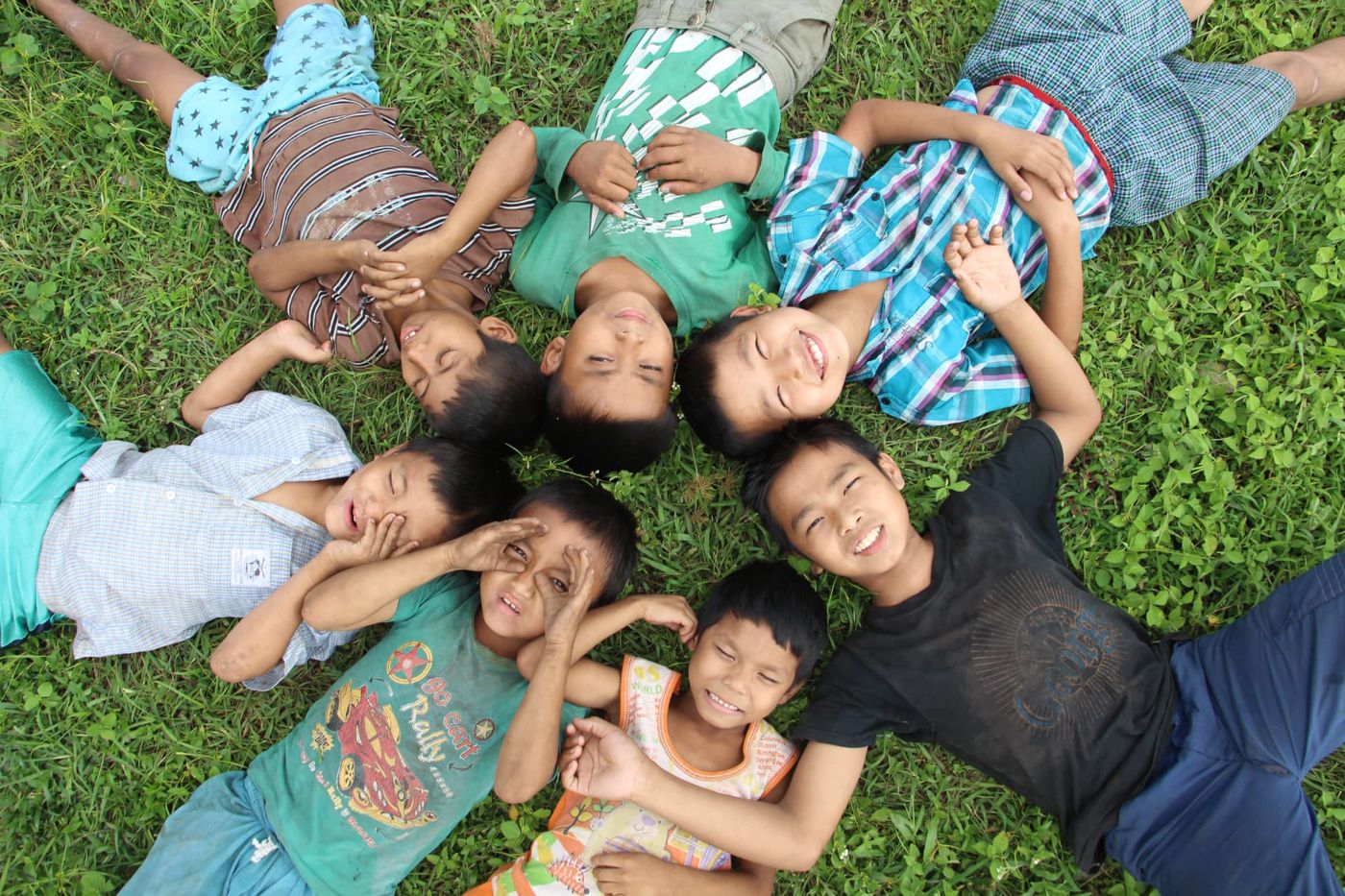 Children lying in a circle on the grass